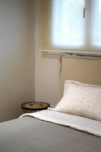 a bedroom with a bed with a window and a pillow at SeaView Apartment Megas Limnionas in Chios