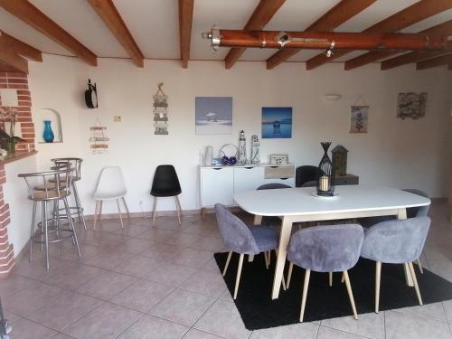 une salle à manger avec une table et des chaises blanches dans l'établissement L Océan En Vendée, à Avrillé