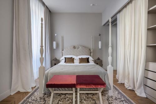 Schlafzimmer mit einem großen Bett und einer roten Bank in der Unterkunft Palazzo Signoria luxury Apartments 2-David in Florenz