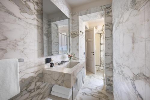 ein weißes Badezimmer mit einem großen Waschbecken und einem Spiegel in der Unterkunft Palazzo Signoria luxury Apartments 2-David in Florenz