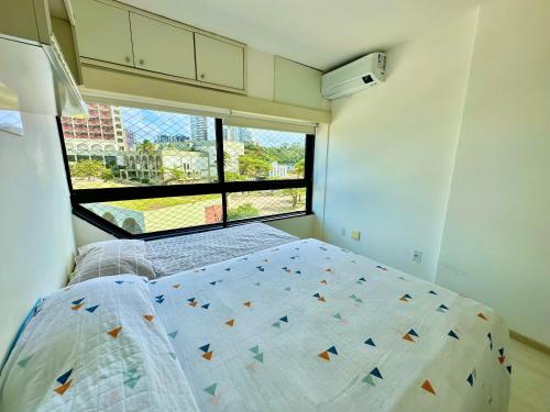 a bedroom with a bed and a large window at Ondina Apart Hotel Residences in Salvador
