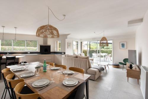 une salle à manger et un salon avec une table et des chaises dans l'établissement Maison pour 8 - Confort et proximité des plages, à Dinard