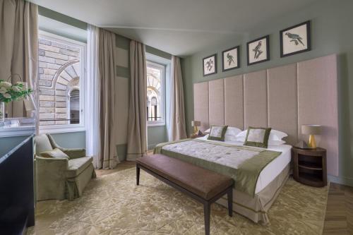 Un dormitorio con una cama y una silla y una ventana. en Apartments Florence - Palazzo Signoria luxury Apartments 5 - Nettuno, en Florencia