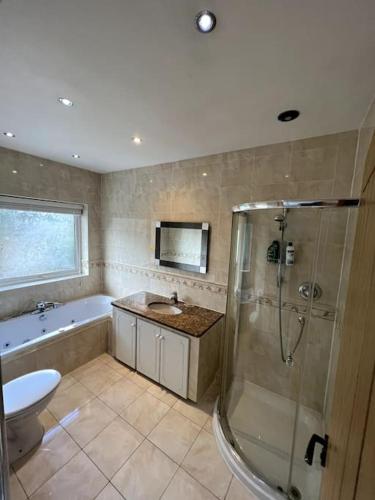 een badkamer met een douche, een wastafel en een toilet bij Large 4 bedroom house, electric gated driveway. 