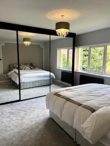 een slaapkamer met een groot bed en een grote spiegel bij Large 4 bedroom house, electric gated driveway. 