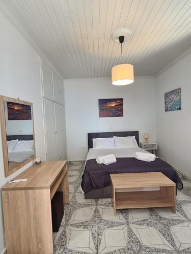 a bedroom with a bed and a table and a mirror at Villa Elia Perigiali Lefkada in Nydri