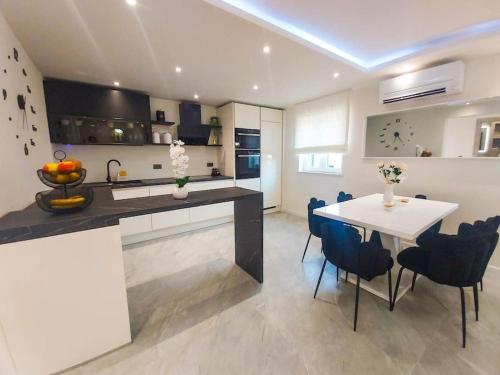 una cucina con tavolo e sedie e una cucina con bancone di Luxury two-bedroom apartment by the sea U KaLu a Postira (Postire)