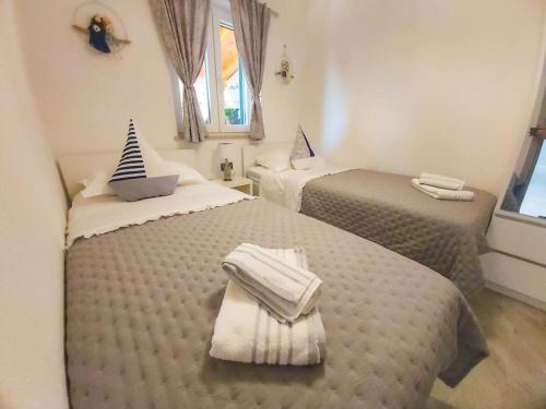 um quarto com 2 camas e toalhas em Luxury two-bedroom apartment by the sea U KaLu em Postira