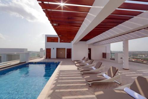 een zwembad op het dak van een gebouw met ligstoelen bij Gallery suites and Apartments in Accra