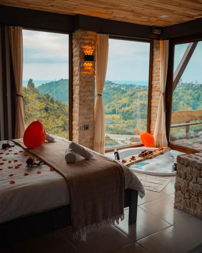 a bedroom with a tub and a bed with a view at Keyfi Teras Bungalov in Rize