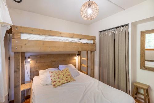 une chambre avec un lit avec une tête de lit en bois dans l'établissement Chalet Pla del Mir - Station de ski à pied, aux Angles