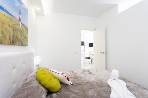 een slaapkamer met een bed met een groen kussen erop bij Home2Book Cozy Apt Colina Blanca Adeje II, Terrace in Adeje