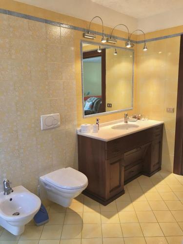 a bathroom with a sink and a toilet and a mirror at B&B La Quercia in Dimaro