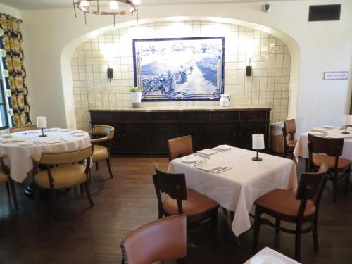 a restaurant with tables and chairs and a painting on the wall at Ponte Vineyard Inn in Temecula