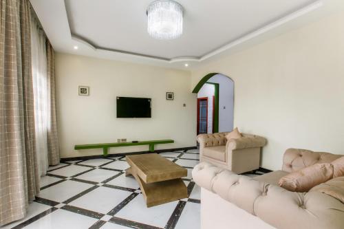 a living room with couches and a tv at Malaika courts in Kampala