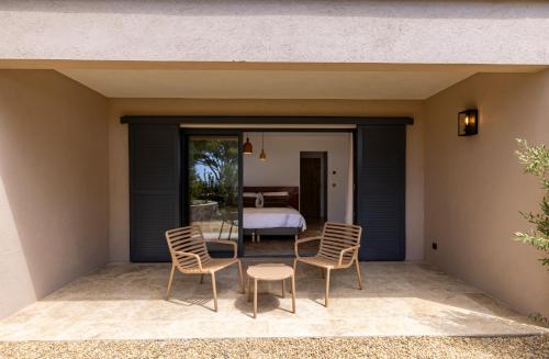 patio z krzesłami i łóżkiem w sypialni w obiekcie Le Refuge - Gigaro Lodges w mieście La Croix-Valmer