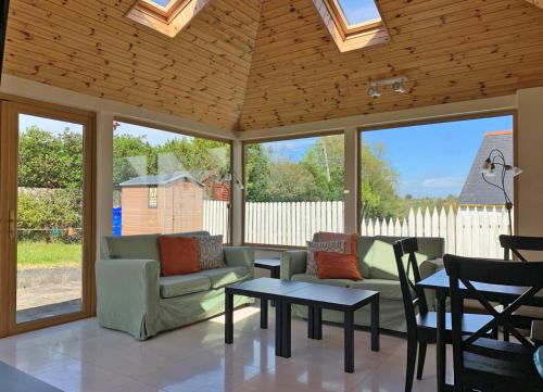 a screened in porch with couches and a table at Bayview Holiday Home No 14 in Dunmore East