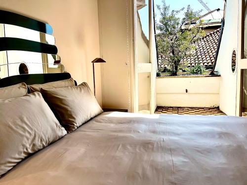 a large bed in a room with a window at Imperial Terrace suite in Milan