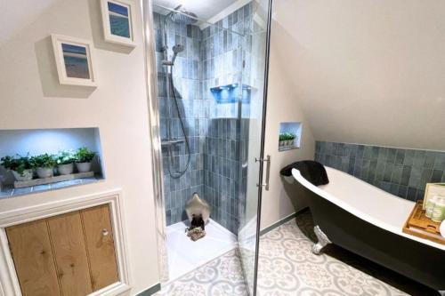 uma casa de banho com um chuveiro, uma banheira e uma banheira com pés. em Piglet's Hideaway em Stratford-upon-Avon