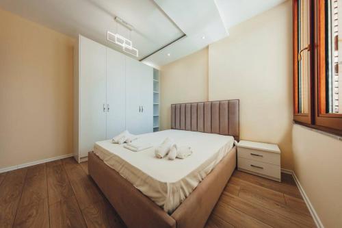 ein Schlafzimmer mit einem Bett mit zwei Handtüchern darauf in der Unterkunft Luxury Apartment at Myslym Shyri in Tirana