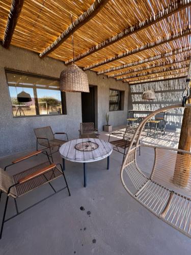 un patio con bancos, mesa y sillas en Casa Vergara 3 en Villa Unión