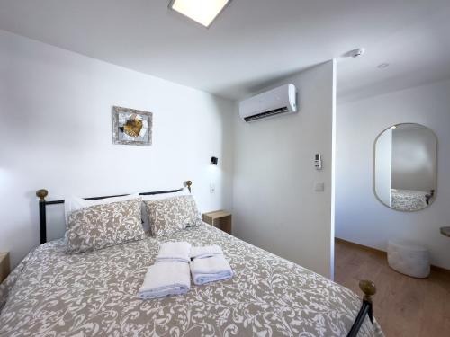 a bedroom with a bed with two towels on it at Casa das Flores in Oliveira do Hospital