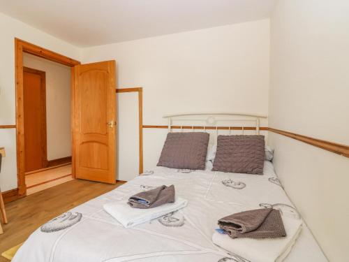 a bedroom with a large bed with towels on it at Old Cooperage in Port Erroll