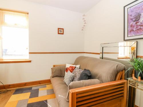 a living room with a couch and a window at Old Cooperage in Port Erroll