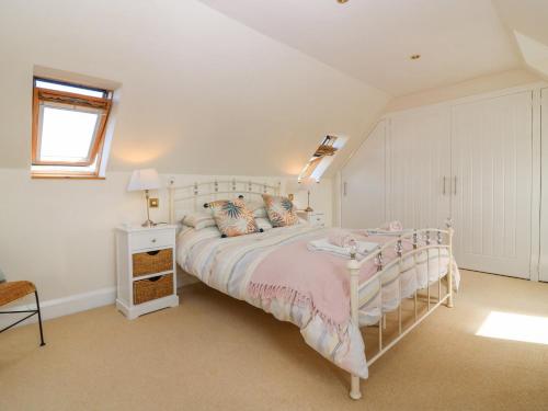 a bedroom with a bed and a table and a window at Old Cooperage in Port Erroll