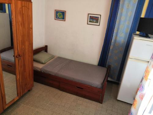 a small bedroom with a bed and a mirror at LocaTriolet in Saint-Denis