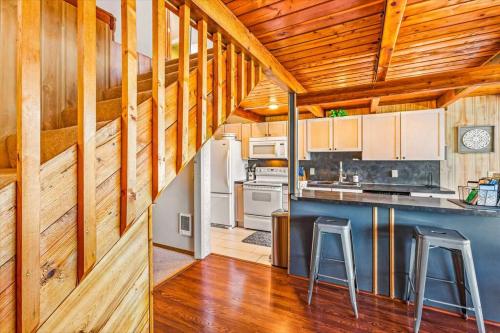 a kitchen with wooden walls and a counter with stools at Utopia Cove in Union