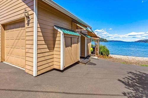 a house with a garage next to the water at Utopia Cove in Union