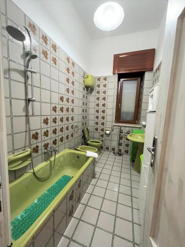 a bathroom with a green tub and two sinks at Il Borgo in Agerola