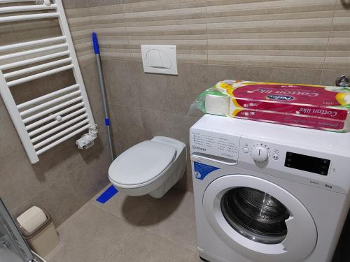 a bathroom with a washing machine and a toilet at Apartman Max in Modriča