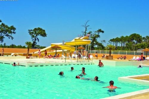 un groupe de personnes nageant dans une piscine dans l'établissement Mobil home 4/6 personnes, à Seignosse