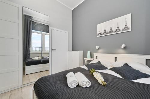a bedroom with a bed with two pillows and a mirror at Architektów Avenue Apartment Free Parking by Renters in Wrocław