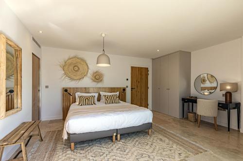 a bedroom with a large bed and a desk at Le Refuge - Gigaro Lodges in La Croix-Valmer