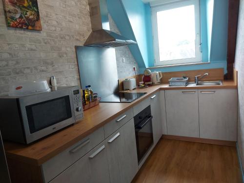 a kitchen with a microwave oven and a sink at Guingamp centre : grand appartement lumineux in Guingamp