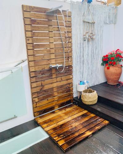 a wooden shower door in a bathroom with a plant at M Costa Nova in Costa Nova