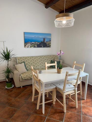 a dining room with a table and chairs and a couch at La mansarda di nonno Calogero in Montelepre