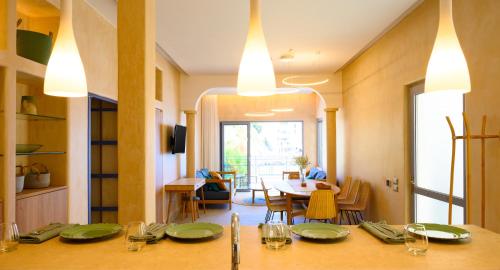 a dining room with a table with green plates on it at Asteria Seafront Luxury Apartment in Agios Nikolaos