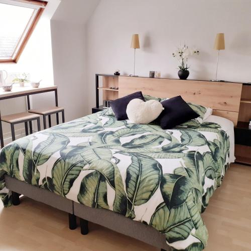 - une chambre dotée d'un lit avec une couverture verte et blanche dans l'établissement Maison de la Loue