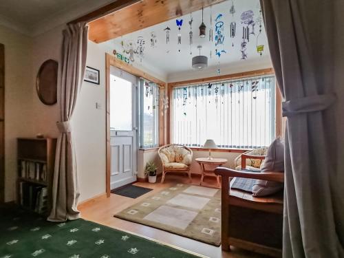 a living room with a large window and a table at Maari in Trumisgarry