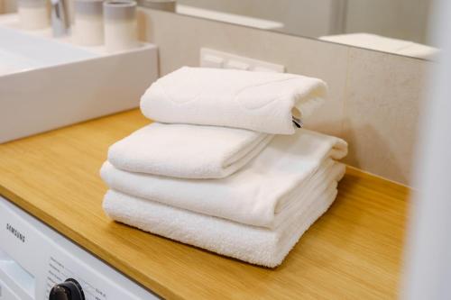 德茲維濟諾的住宿－Apartament CLOUDS SurfingBird Dźwirzyno，浴室的台面上摆放着一堆毛巾