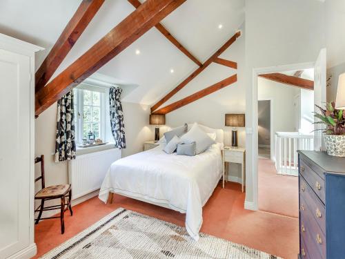 um quarto com uma cama branca e tectos em madeira em Beautiful Cottage In Shaftesbury With 3 Bedrooms And Wifi em Shaftesbury
