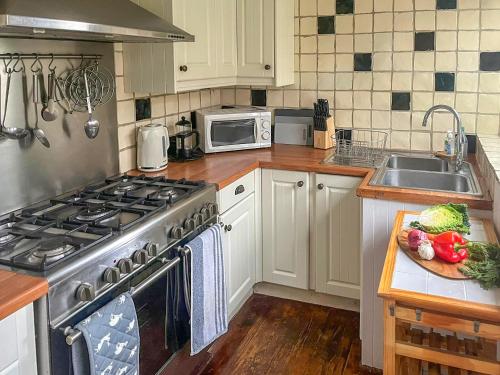 a kitchen with a stainless steel stove and a sink at Swallows Way in Briston