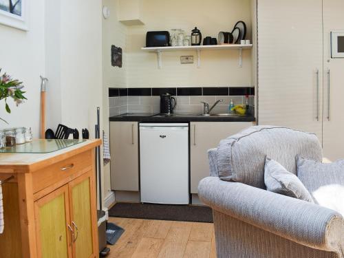 una pequeña cocina con fregadero y sofá en Gracies Cottage - Uk44686 en Burnopfield