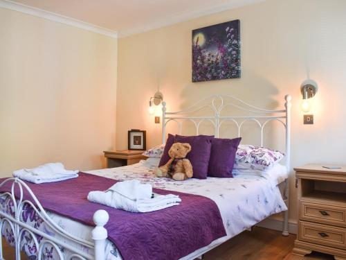 a teddy bear sitting on a bed with towels at Gracies Cottage - Uk44686 in Burnopfield