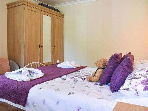 a teddy bear sitting on top of a bed at Gracies Cottage - Uk44686 in Burnopfield