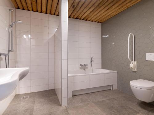 La salle de bains est pourvue d'une baignoire, de toilettes et d'un lavabo. dans l'établissement Ecological bungalow with decorative fireplace, located on a holiday farm, à Heeten